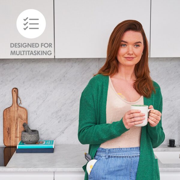 Woman drinking coffee with both hands free using Solo breast pump