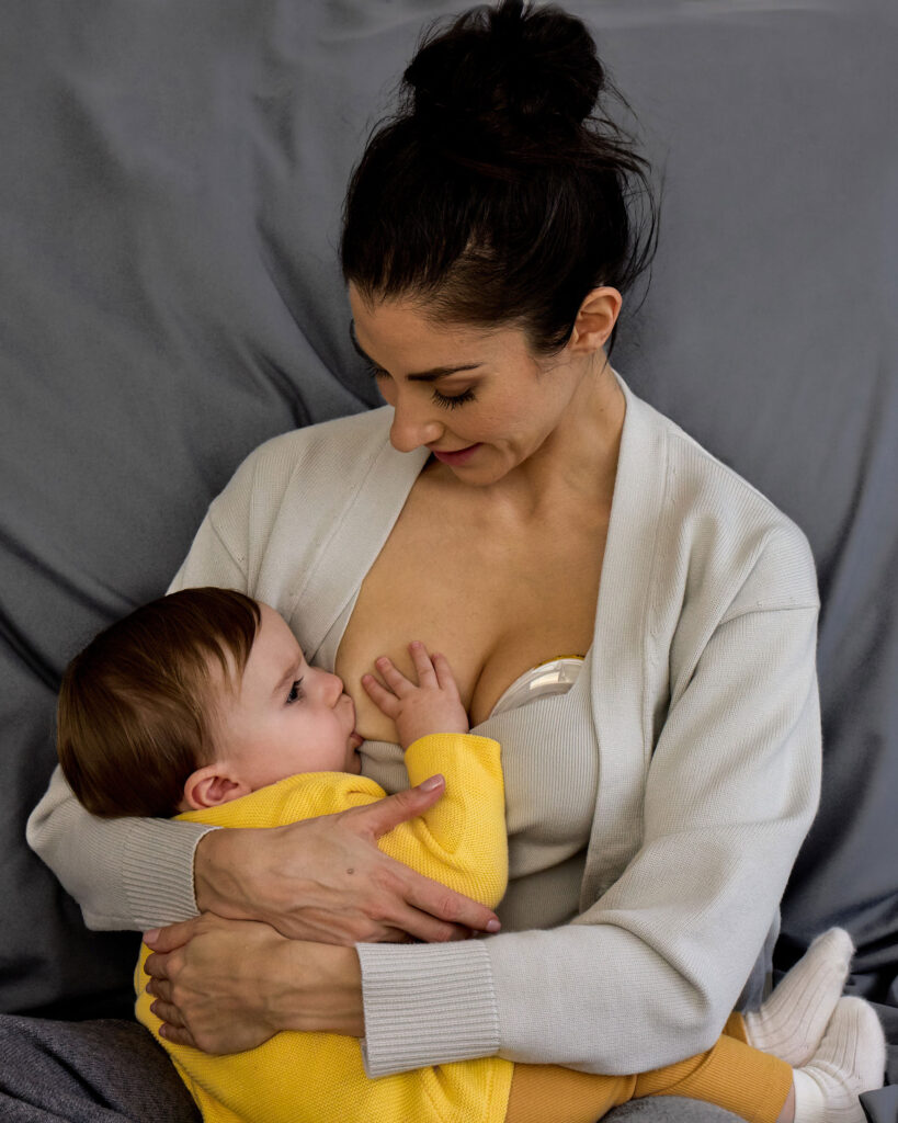 Mum breastfeeding baby while breast pumping on other breast