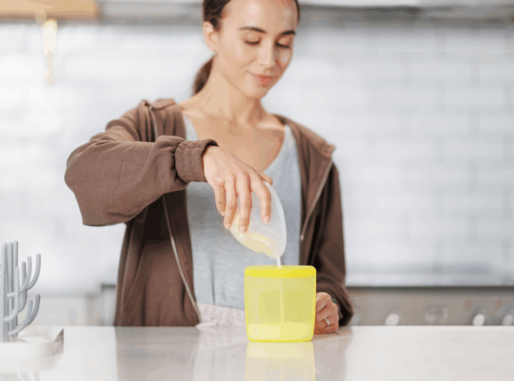 Mother pouring breast milk into the Medela silicone reusable breast storage bag